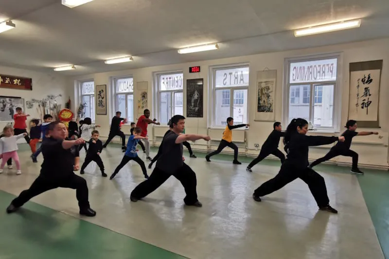 A group of students practicing Shaolin Kung Fu in a group class