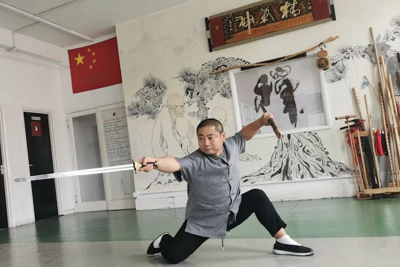 Shifu with long sward in Tai Chi stance with sward pointing forward