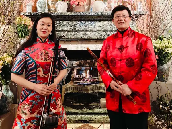 Two Chinese Musicians posing with a Chinese fiddle and a bamboo flute