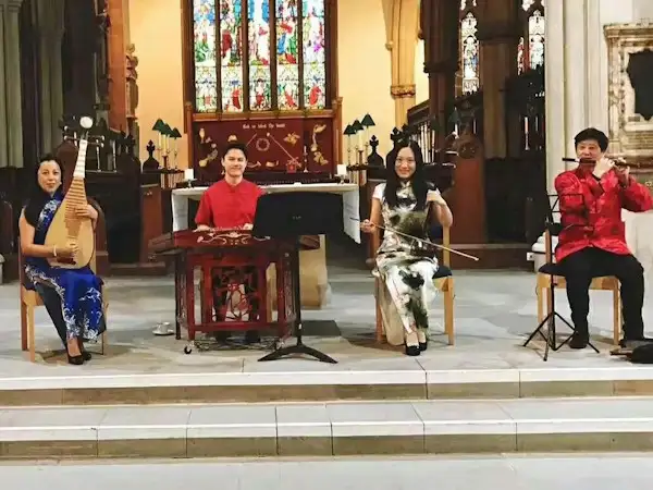 Four musicians performing traditional Chinese music with guzheng and erhu