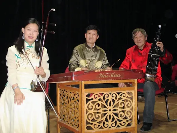 Three musicians preparing to perform traditional Chinese music with Erhu, Yangqin and Sheng