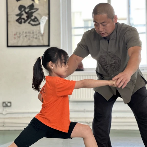 A student receiving guidance on proper martial arts form stance